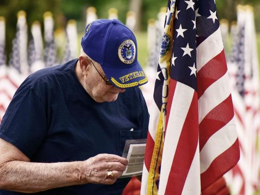 older veteran man looking at flag